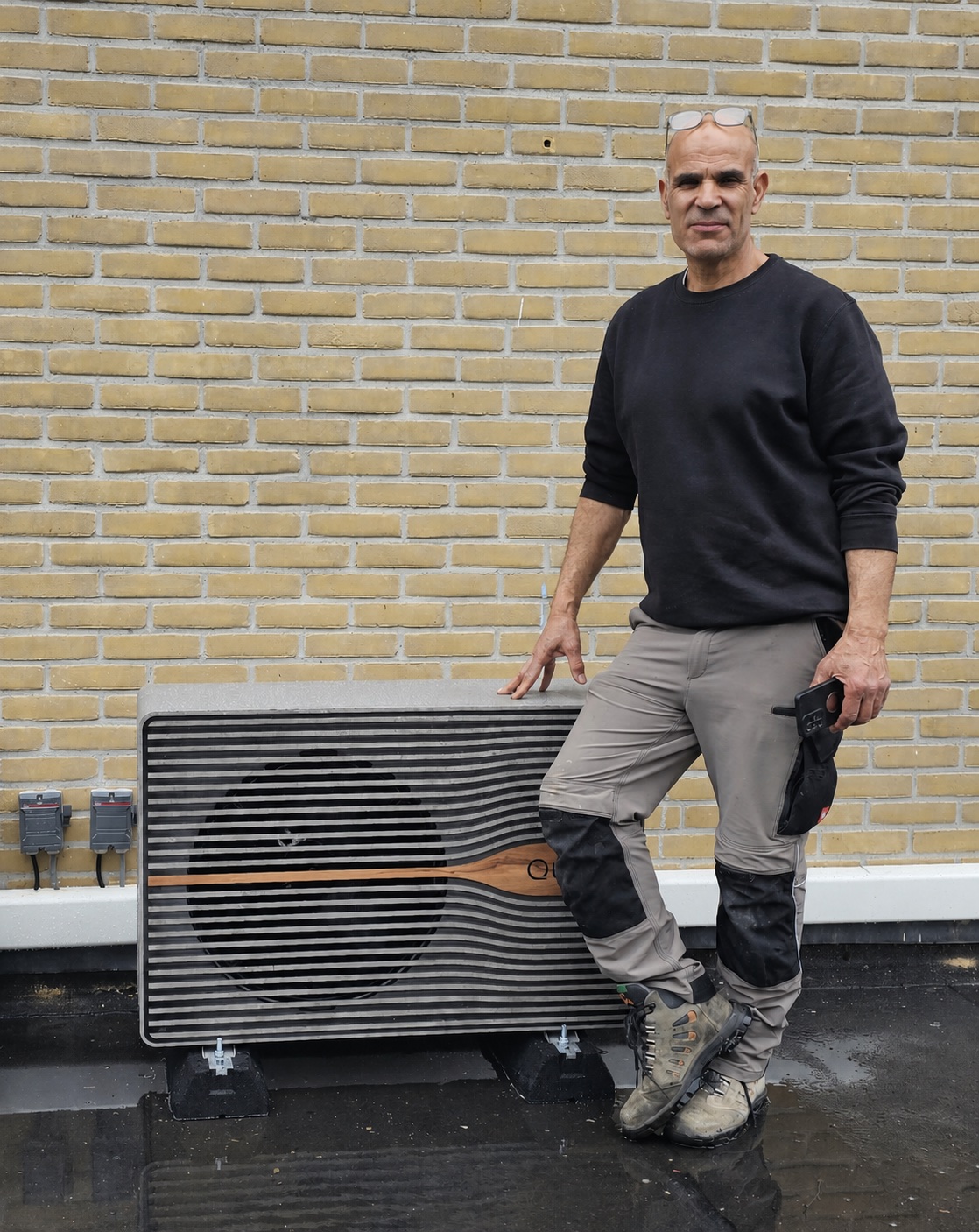 Installateur bij een geplaatste warmtepomp-buitenunit